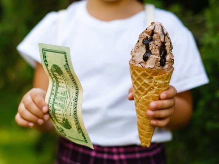 girl holding ice cream cone and money as rewards