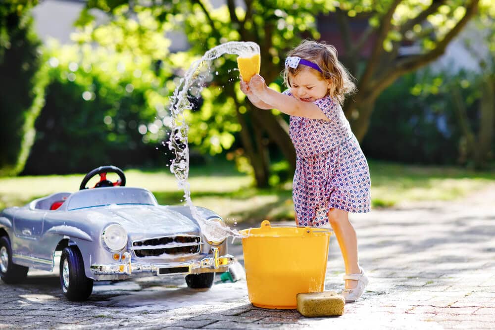 little girl washing her toy car