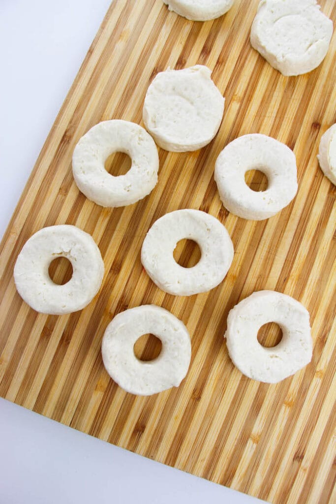 biscuit dough in a donut shape on a cutting board