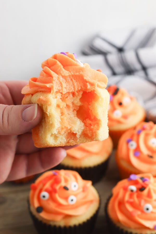 inside of an orange poke cake cupcake decorated for Halloween