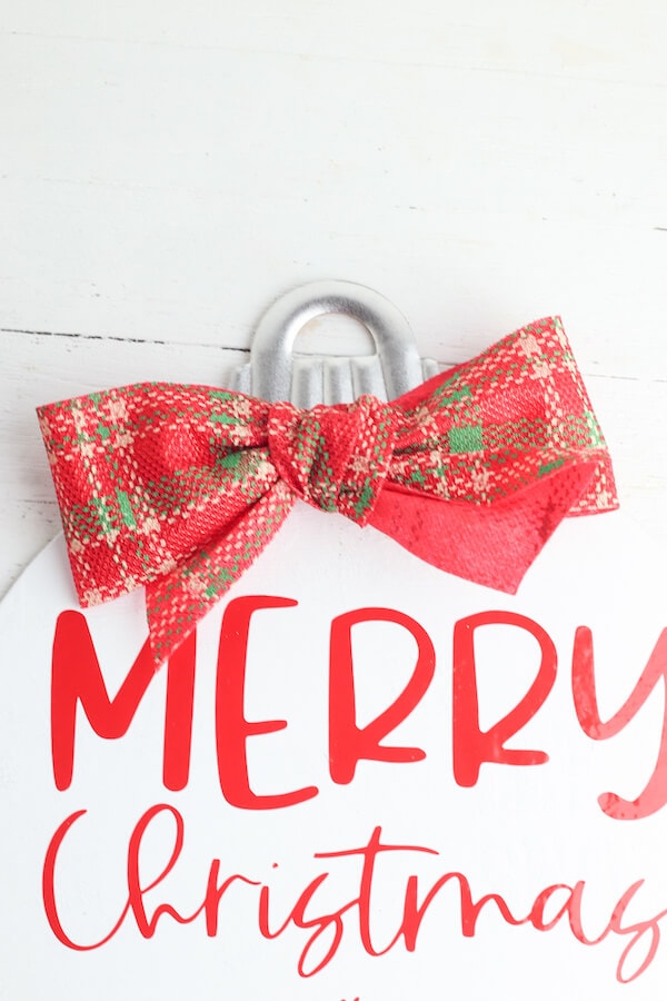 red plaid bow tied onto wood Christmas sign