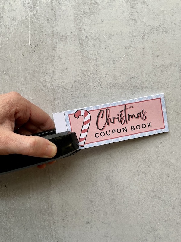 stapling a DIY Christmas coupon book together