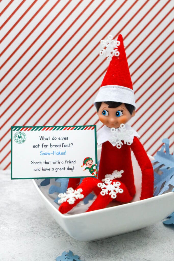 Elf on the Shelf in a bowl of paper snowflakes