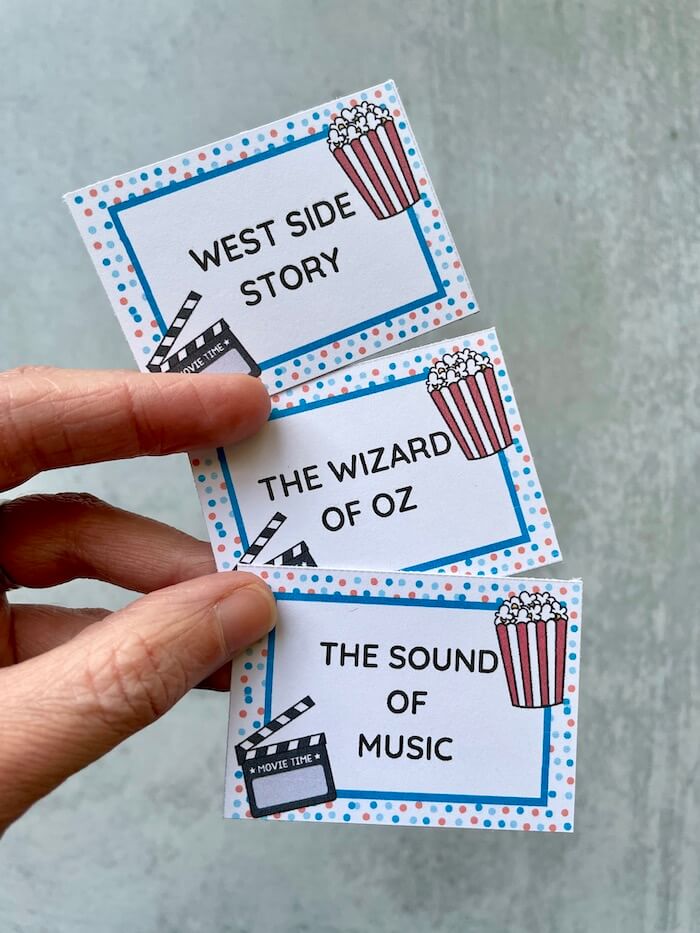movie charades cards that say "West Side Story", "The Wizard of Oz", and "The Sound of Music"