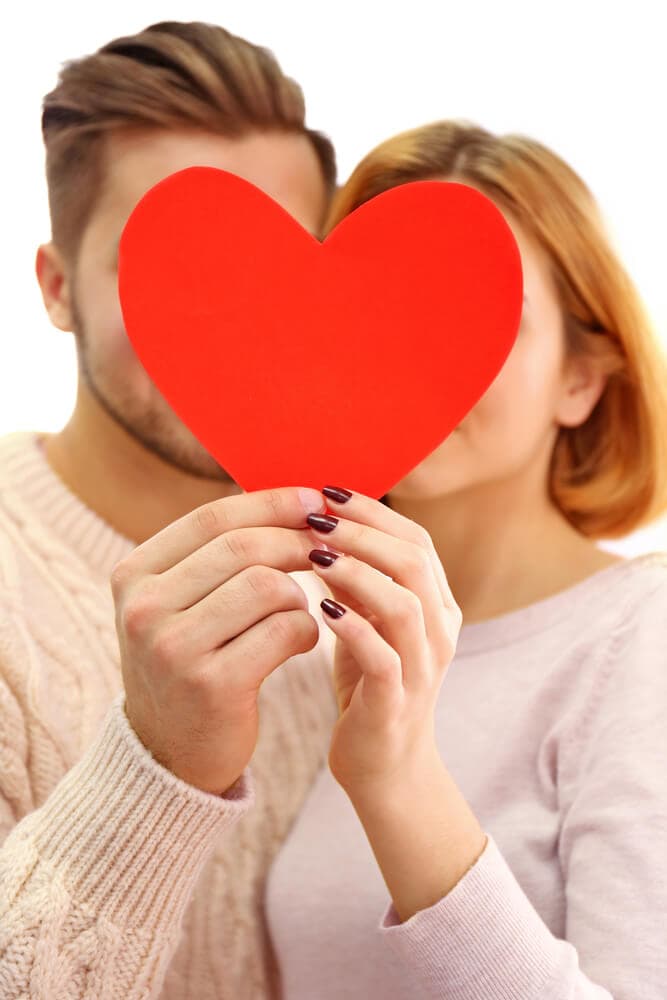 couple holding a red paper heart