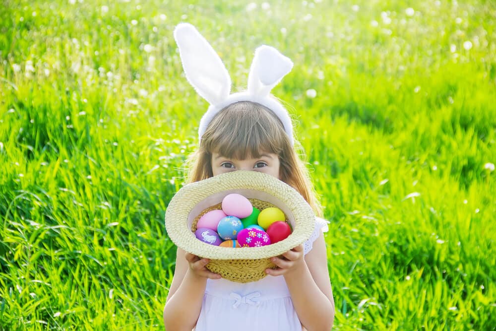girl holding a basket of plastic Easter eggs