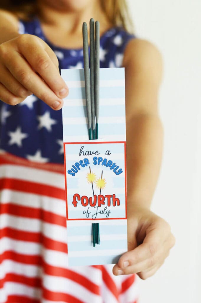 girl holding a Fourth of July sparklers party favor