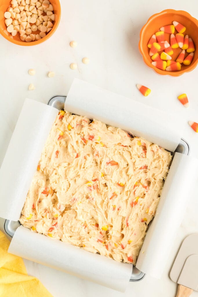 candy corn cookie dough in a baking pan with parchment paper
