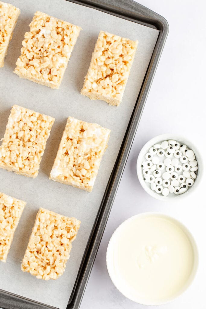 cut rice krispie treats, melted white chocolate, and candy eyes