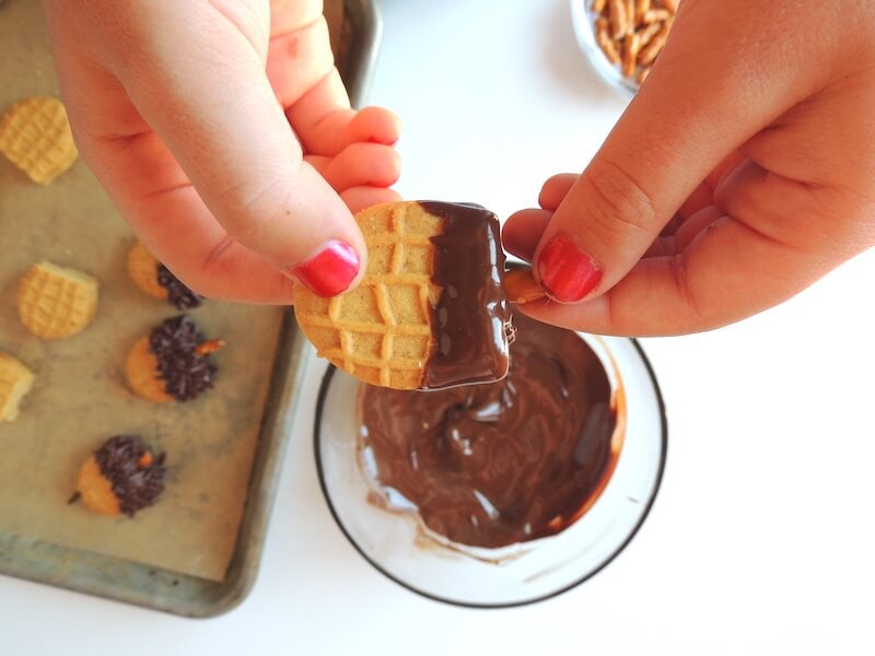 making acorn cookies with Nutter Butters and melted chocolate