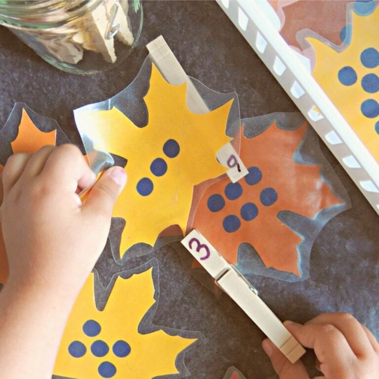 child doing the fall number matching activity with leaf cards