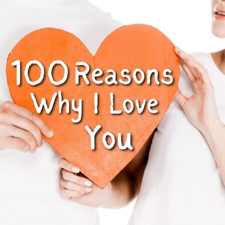 couple holding paper heart that says 100 reasons why I love you