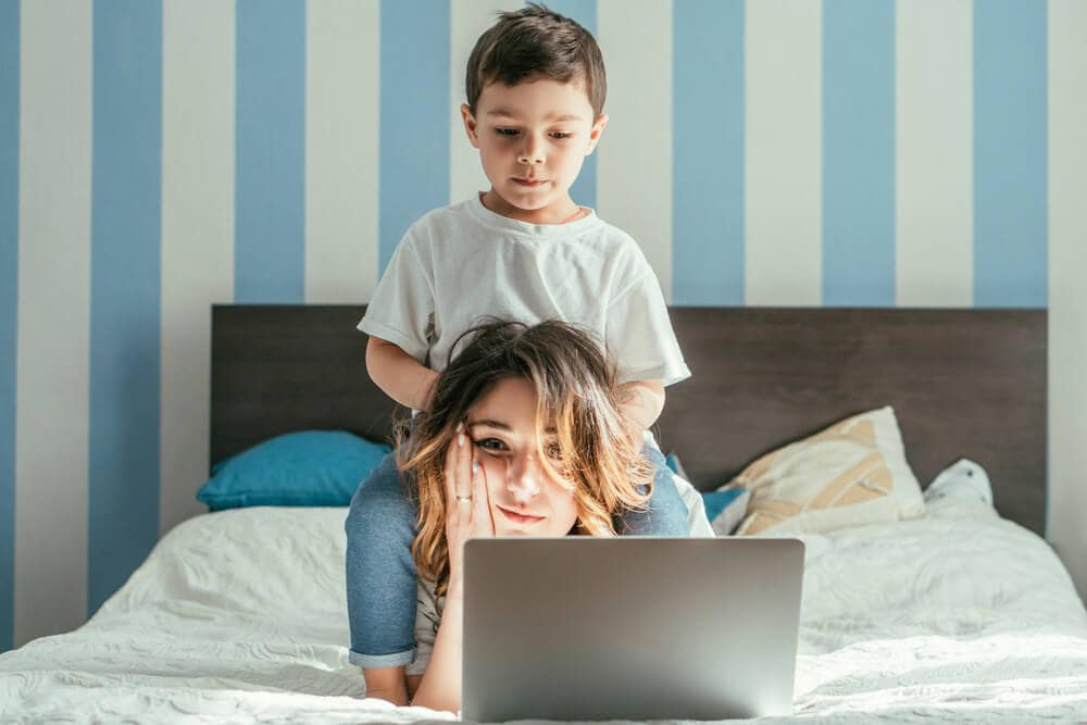 exhausted mom trying to work on a computer