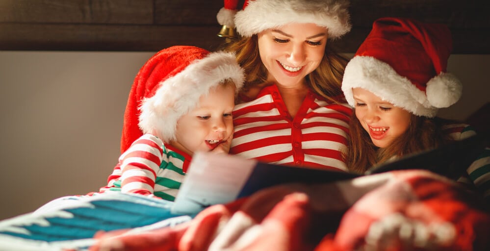 mother reading Christmas book to kids
