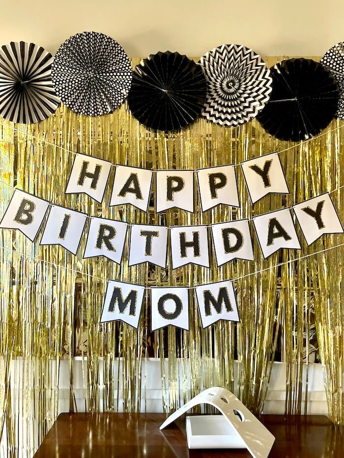 black and gold DIY birthday banner on gold backdrop