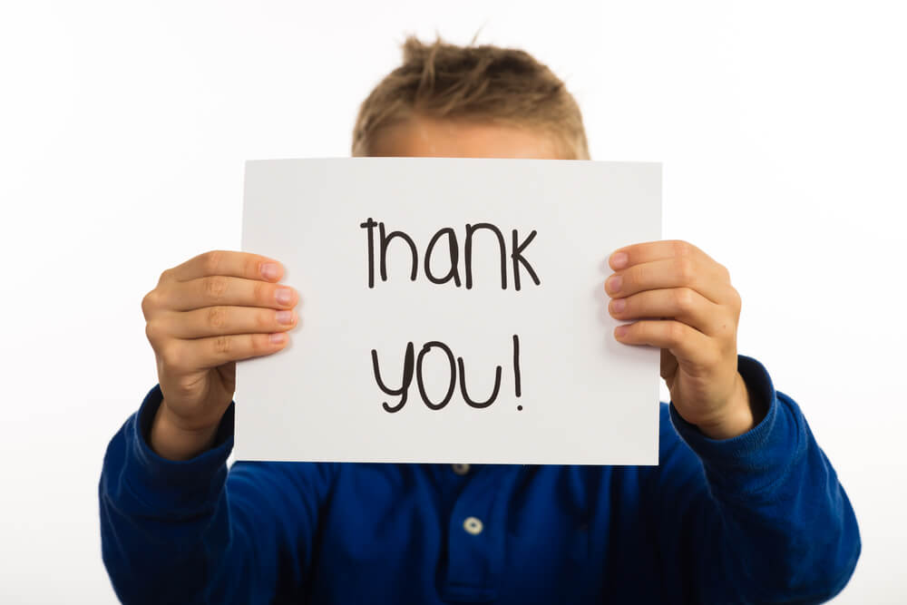 boy holding up sign that says thank you