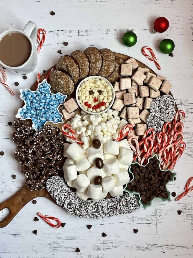hot chocolate dessert charcuterie board with marshmallows in a snowman shape