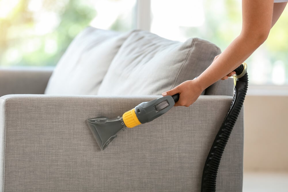 woman vacuuming a couch