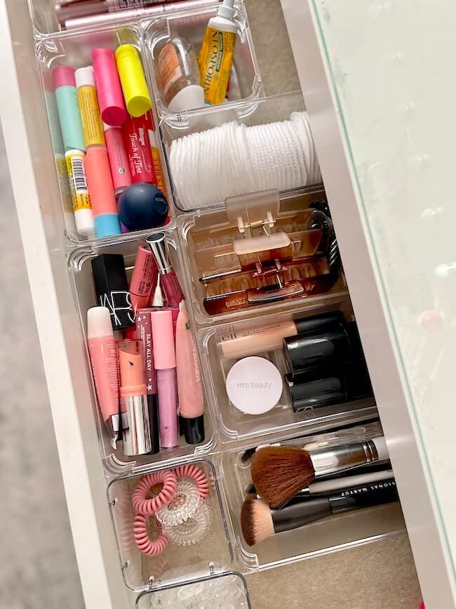 a vanity drawer with makeup and plastic drawer organizers