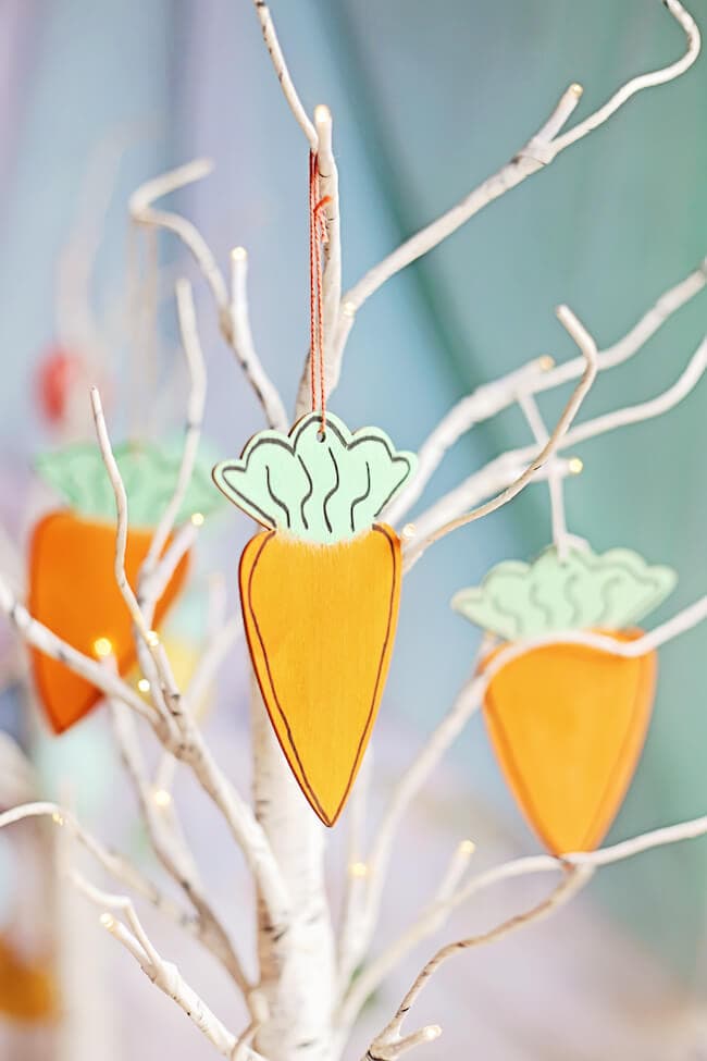 painted wooden carrot ornaments hanging on an Easter tree