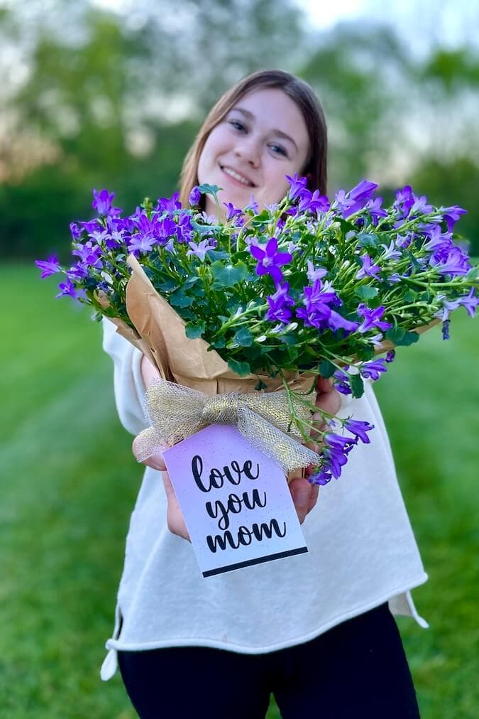 Mother's day gift tag that says love you Mom tied around a flower