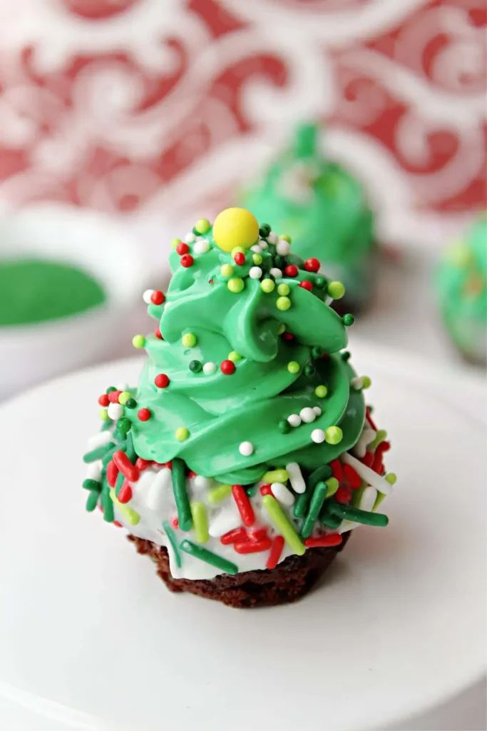 brownie bites with frosting in the shape of Christmas trees