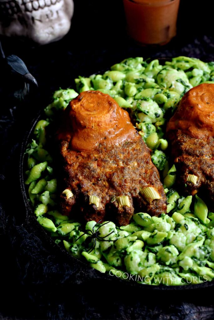 meatloaf shaped like a foot on top of green mac and cheese