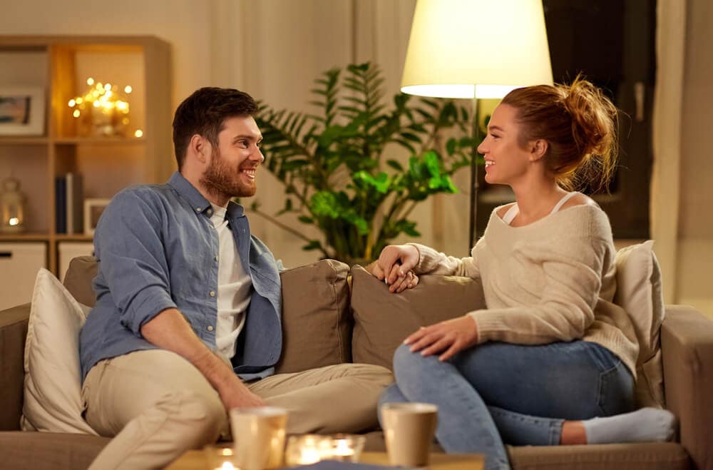 married couple talking on a couch