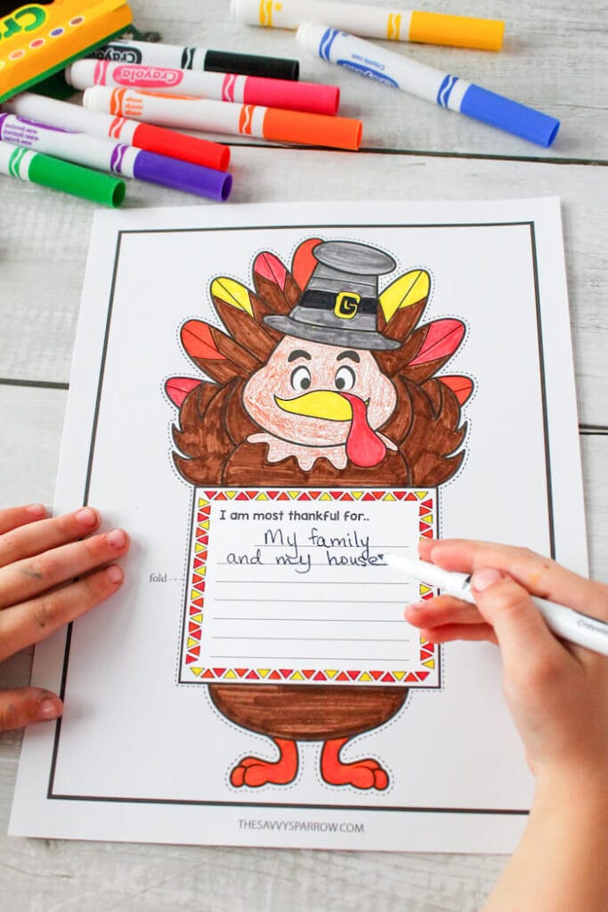 coloring a Thanksgiving writing template that says I am thankful for