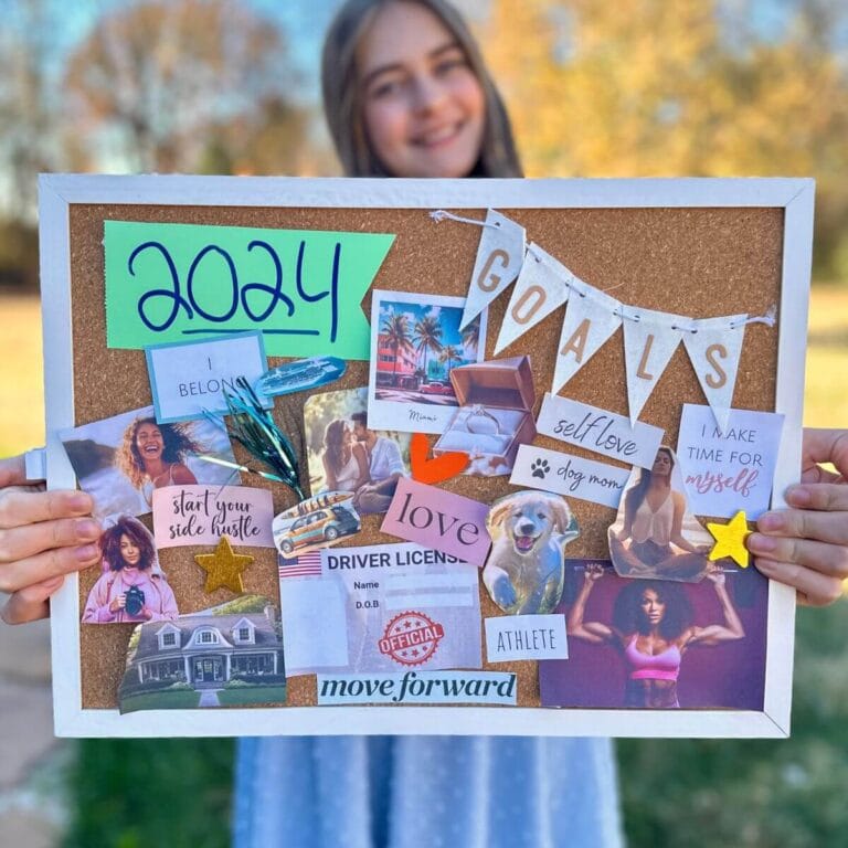girl holding a vision board with goals and pictures