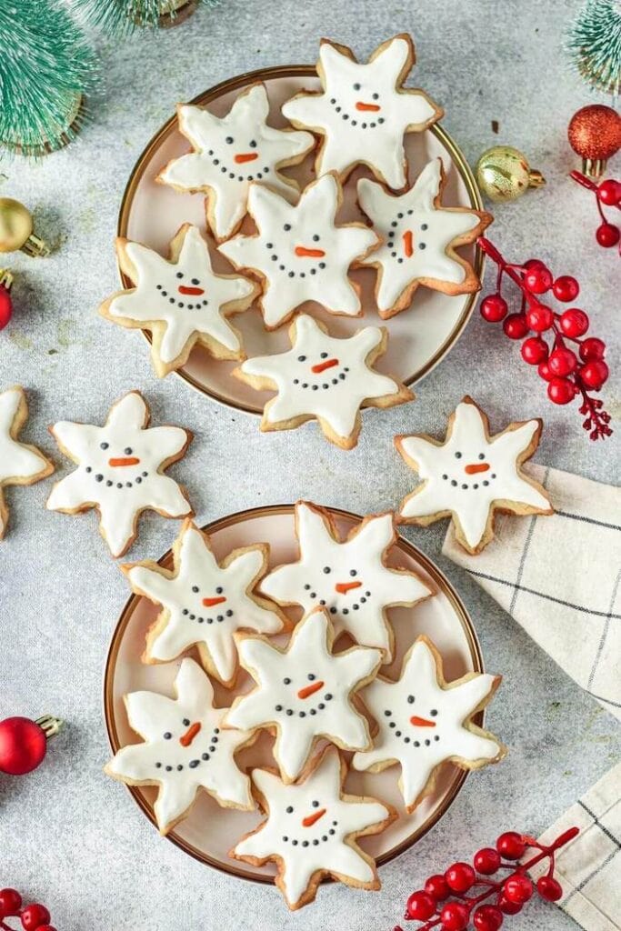 snowflake shaped cookies with snowman faces