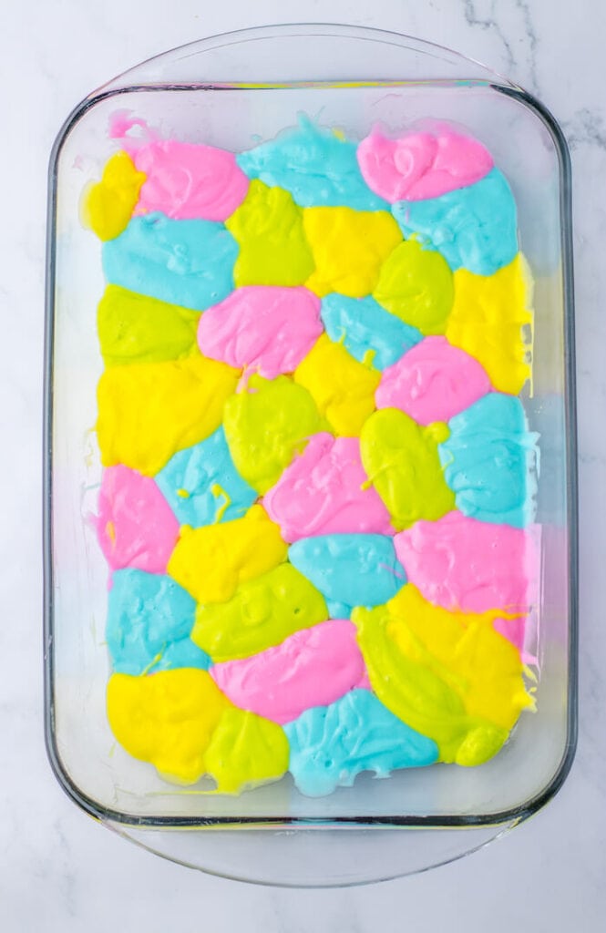 pastel colored cake batter in a glass baking dish
