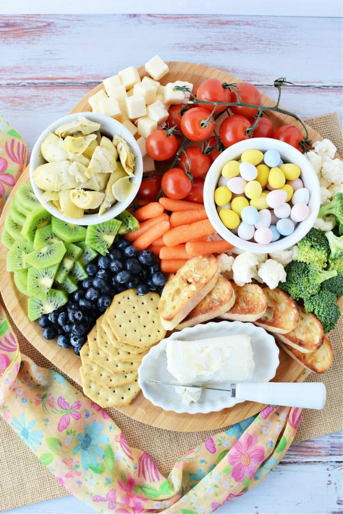 Easter snack tray with vegetables, cheese, crackers, and fruits
