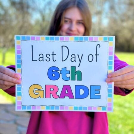 girl holding up a last day of school sign