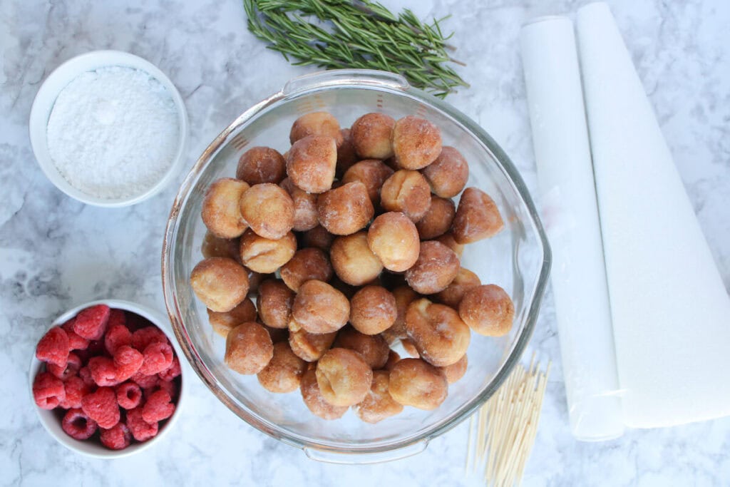 donut holes, raspberries, powdered sugar, and rosemary