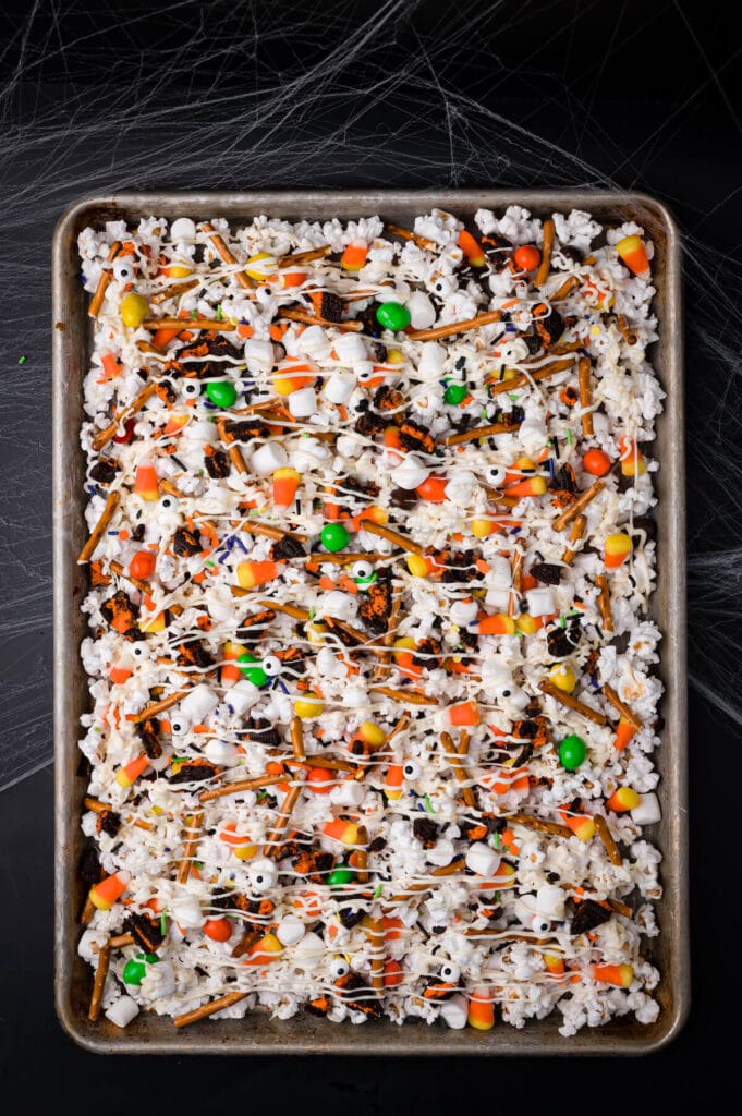 making Halloween popcorn with candy and chocolate drizzle