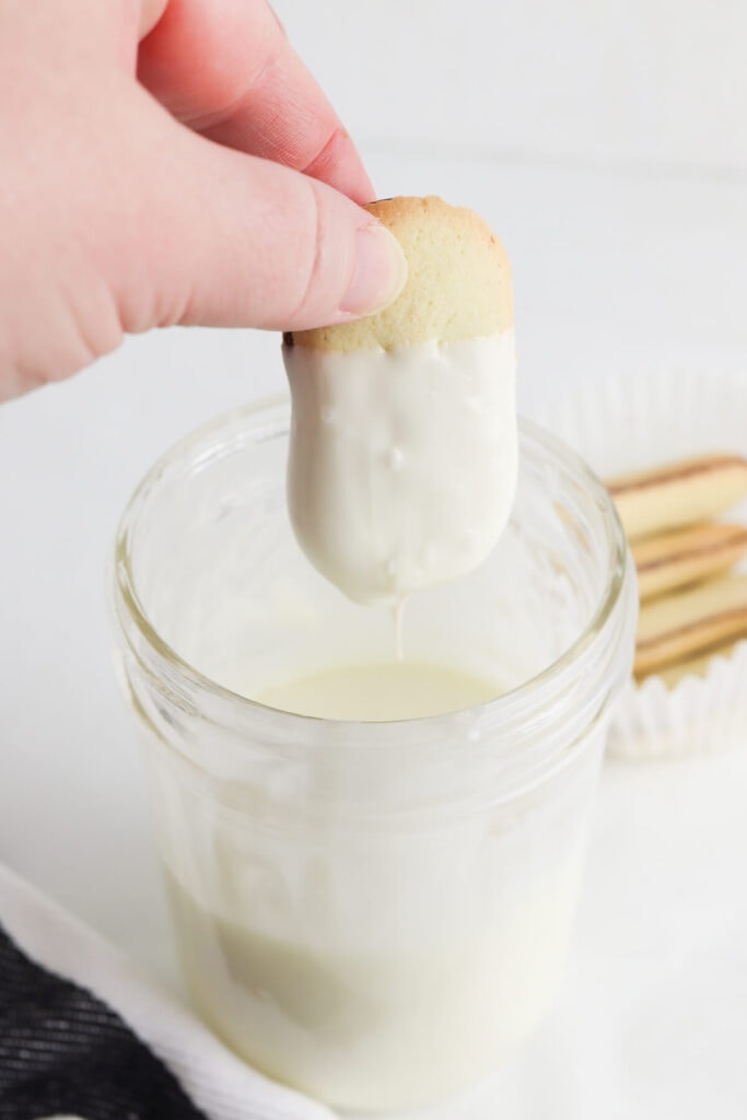 dipping Milano cookies in white chocolate