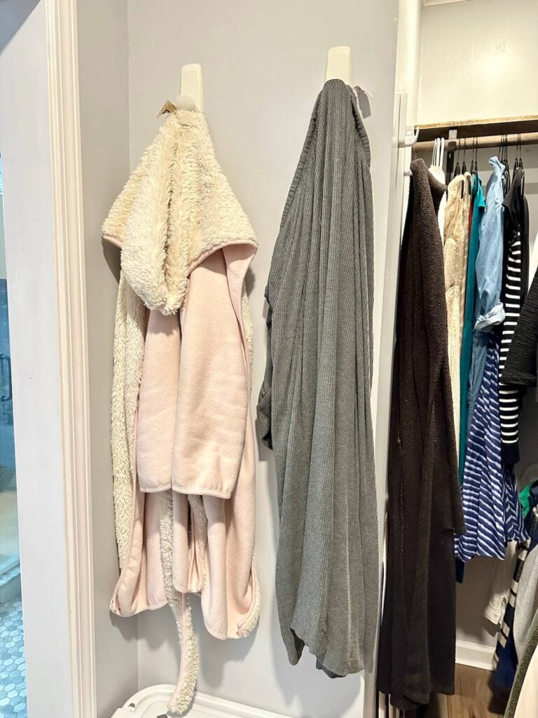 clothes hanging on command hooks in a closet