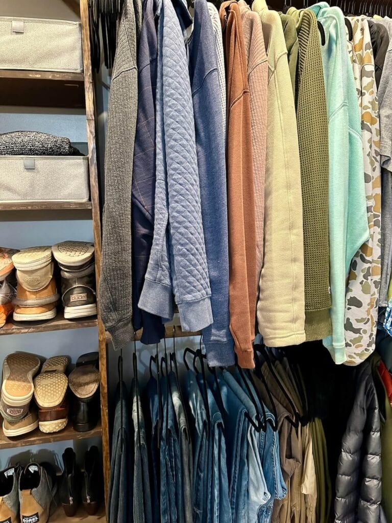clothes hung up in color coordinated order in a master closet