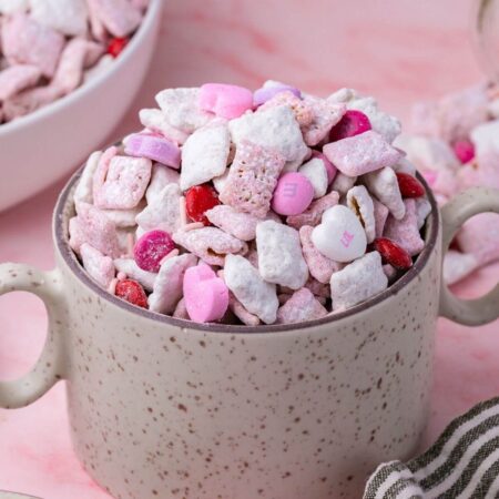 pink Valentine's Day puppy chow snack mix in a mug