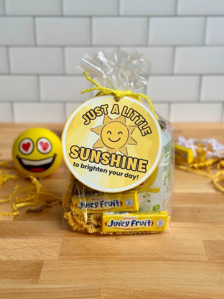 small gift bag of yellow items like candy and gum with a printable gift tag that says "just a little sunshine to brighten your day"