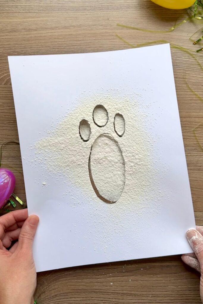 lifting the free printable bunny footprint stencil off the floor
