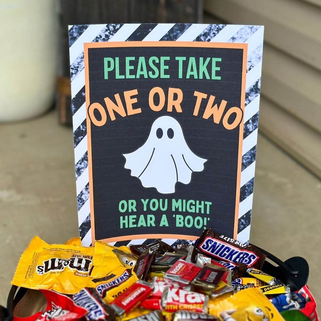 please take one Halloween sign in a candy bowl
