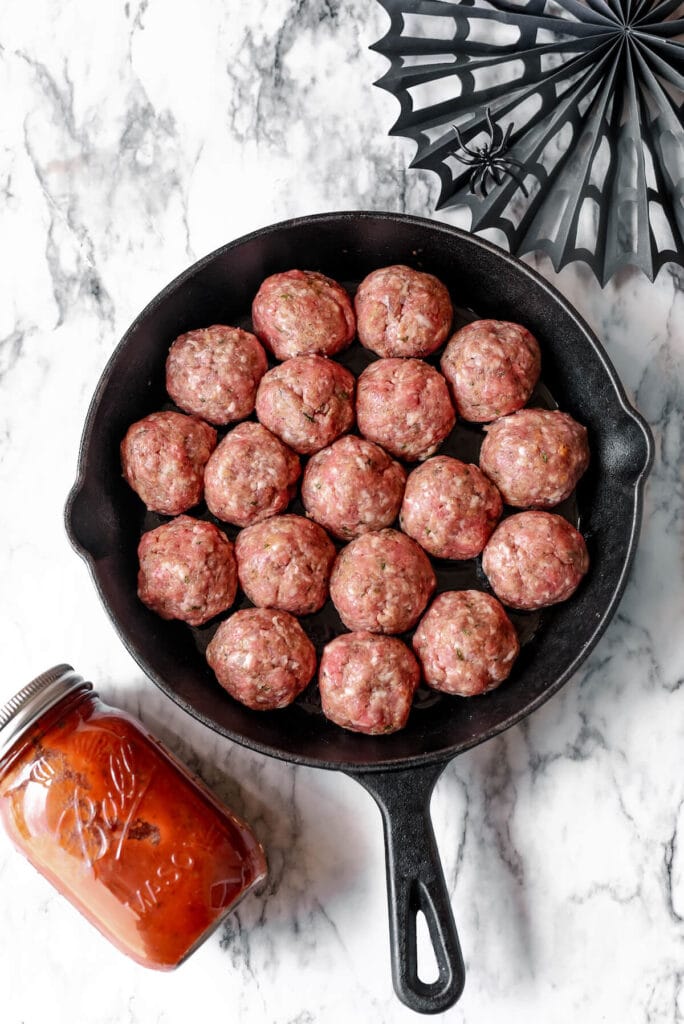 raw meatballs in a cast iron skillet