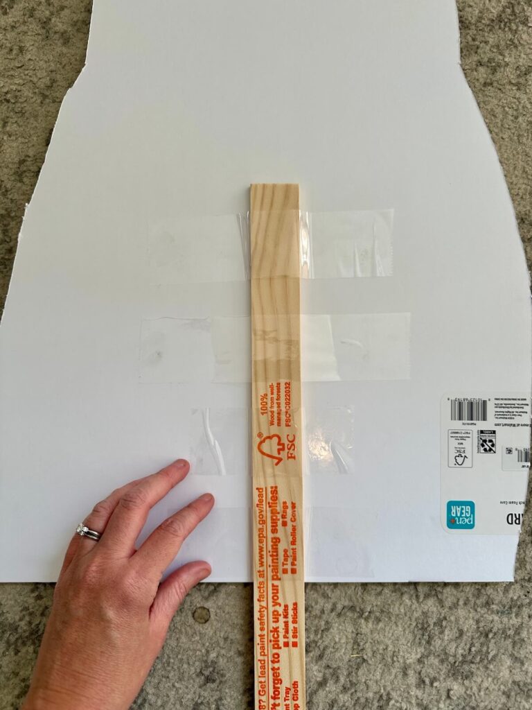 taping a painter stick to the back of a big head cut out