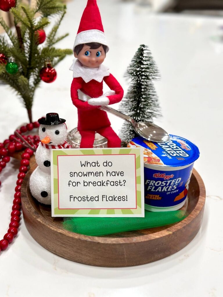 Elf on the Shelf with a bowl of frosted flakes and a joke card