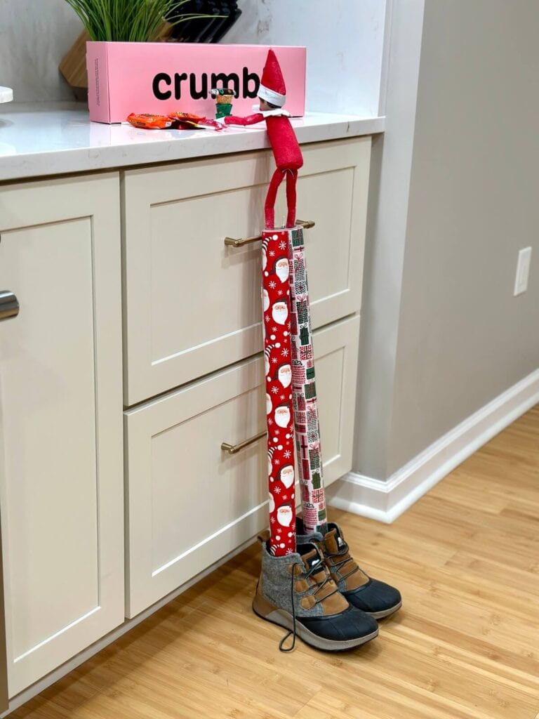 Elf on the Shelf using wrapping paper rolls as stilts