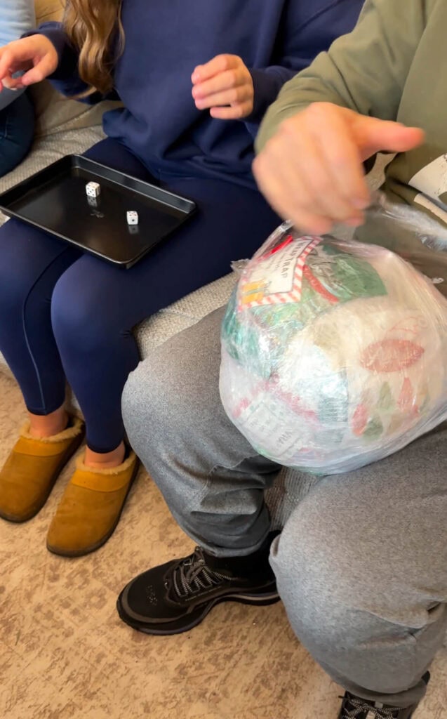 people playing the Saran wrap ball game while sitting on a couch
