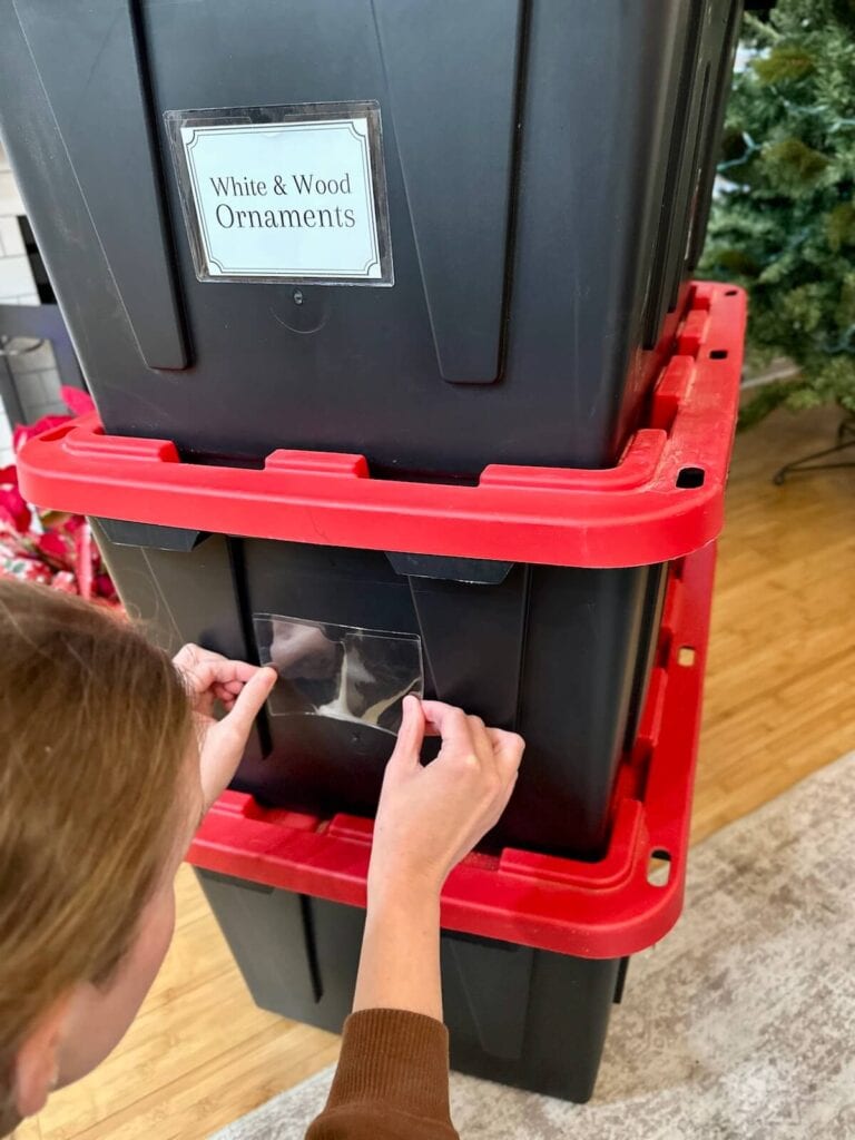 putting labels on storage bins for Christmas decor