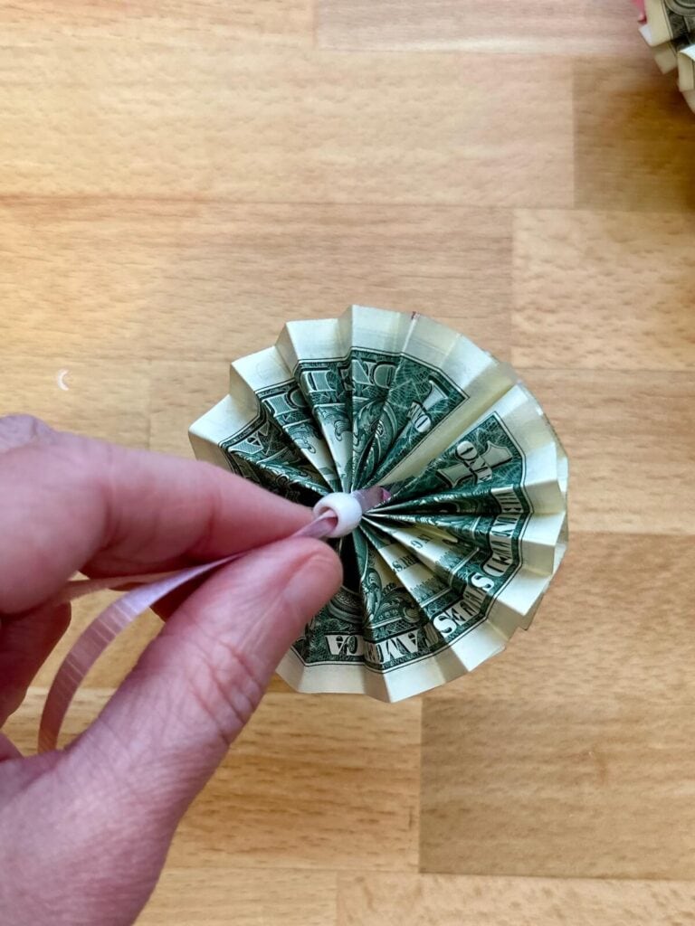 stringing beads and folded dollar bills